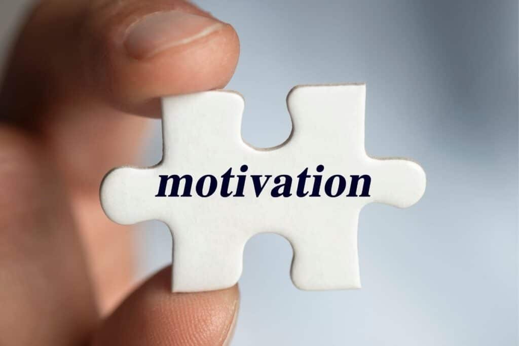 a man holding a puzzle piece of motivation block