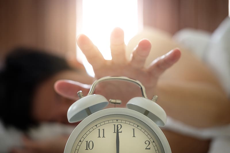 The hand under the blanket extends to the alarm clock in the morning, with light orange.